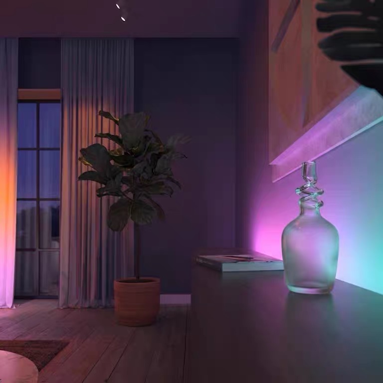 A glass vase catching cyan and pink light from behind a cabinet