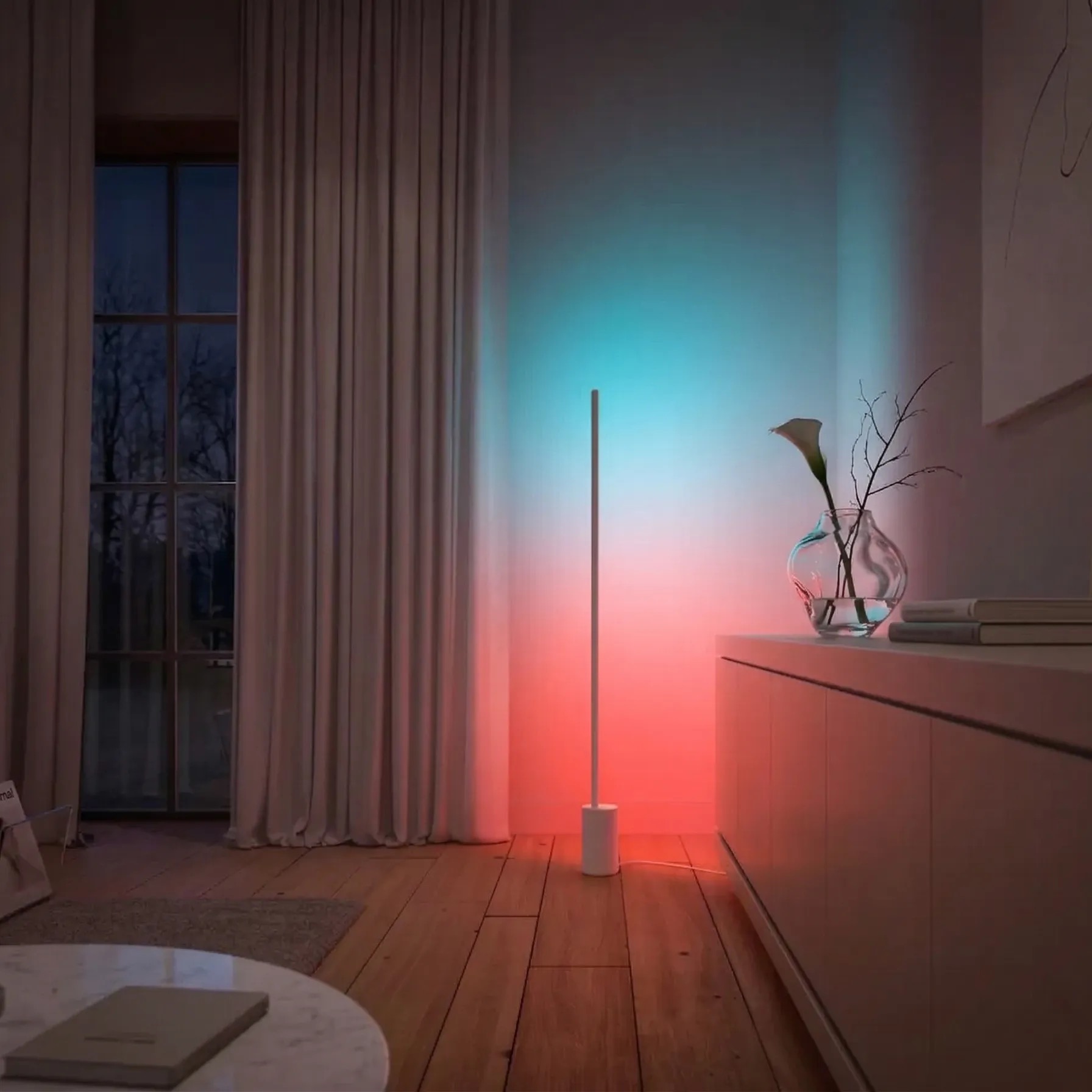 A slender floor lamp beside curtains with cyan and warm colour on the wall